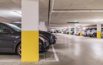 Parking area with multiple cars in a well-lit garage located at Hullenbergweg 109-135, Amsterdam South East. Ideal for those seeking office space rental with convenient parking options.