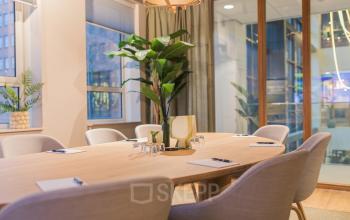 Light-filled conference room at Hullenbergweg 109-135, Amsterdam South East, featuring a modern wooden table with chairs, suitable for office space rental.