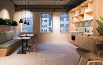 Furnished office space for rent at Hullenbergweg 109-135 in Amsterdam South East, featuring a modern kitchenette and seating area with ample natural light.