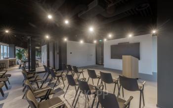 Conference room at Herikerbergweg 290 in Amsterdam South East featuring rows of chairs and a podium, ideal for office space rental.