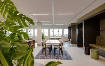 Bright and open office space with a large table and chairs, surrounded by greenery, available for rent at Herikerbergweg 290, Amsterdam South East.