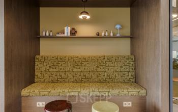 Cozy nook with patterned seating and shelves at Herikerbergweg 290, ideal for office space rental in Amsterdam South East.