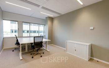 Modern office space for rent at Herikerbergweg 290 in Amsterdam South East, featuring a light-filled room with two workstations and ergonomic chairs.