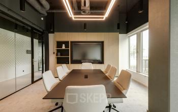 Modern conference room in Amsterdam South East with sleek lighting and a large table, ideal for office space rental.