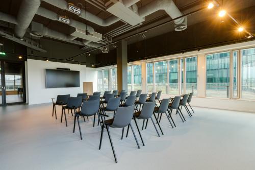Interior office space at Herikerbergweg 290, showcasing a furnished conference room with chairs arranged for presentations, available for office space rental in Amsterdam South East.
