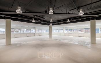 Open floor plan office space rental at Hogehilweg 8 in Amsterdam South East with large windows providing ample natural light.