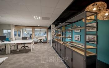 Spacious and modern office space at Hogehilweg 8, Amsterdam South East with desks, a shelving unit, and natural lighting for office space rental.