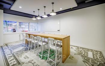 Spacious conference room at Hogehilweg 8, Amsterdam South East, featuring a wooden table, whiteboard, and modern lighting for office space rental.