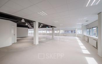 Spacious office interior with large windows and ample natural light at Hogehilweg 8, Amsterdam South East. Ideal office space rental option.