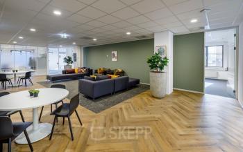 Modern office interior at Karspeldreef 8, Amsterdam South East, featuring contemporary lounge area and meeting spaces, ideal for office space rental.