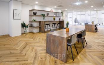 Modern office space rental at Karspeldreef 8 in Amsterdam South East with stylish wooden floors, open workspace areas, and contemporary furniture.