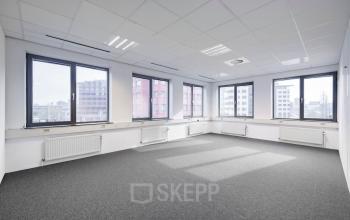 Unfurnished office space with large windows, natural light, and grey carpet at Karspeldreef 8, Amsterdam South East.