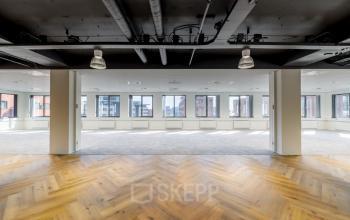 Spacious and bright office to rent at Karspeldreef 8, Amsterdam South East, featuring large windows and stylish wood flooring.