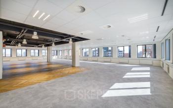 Bright open floor plan inside the Karspeldreef 8 office building in Amsterdam South East, ideal for office space rental with modern finishes and large windows.
