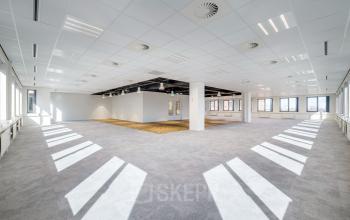 Spacious open floor plan office space at Karspeldreef 8, in Amsterdam South East, Amsterdam, featuring plenty of natural light and modern ceiling fixtures, available for office space rental.