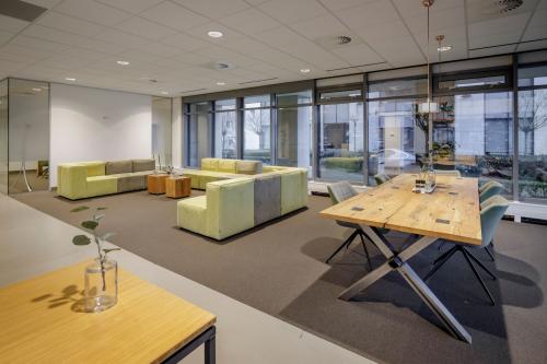 Bright office space with modern furnishings, including lounge area and conference table at Karspeldreef 8, Amsterdam South East.