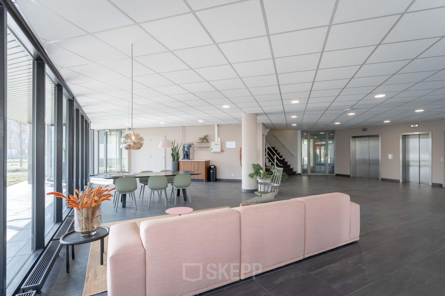 Modern office space with a large seating area, tables, and chairs located at Hogehilweg 4, Amsterdam South East, Amsterdam, available for office space rental.