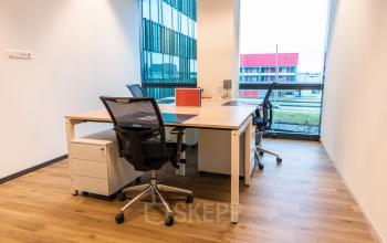 Bright office space for rent at Herikerbergweg 292, Amsterdam South East, featuring modern desks and chairs with a view of the surrounding area.