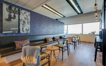 Bright office space in Amsterdam South East with seating and decorative wall art, available for office space rental.
