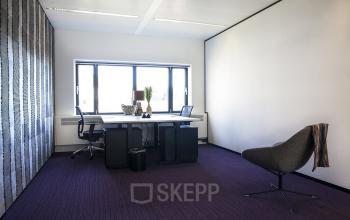 Modern office space at De Entree 99-197, Amsterdam South East, featuring large windows, desks, and ergonomic chairs.