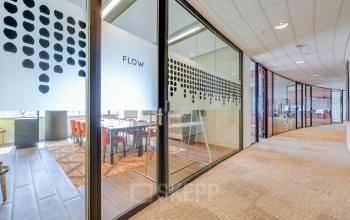 Interior view of an office space located at De Entree 99-197 in Amsterdam South East, featuring glass walls and modern decor, ideal for office space rental.