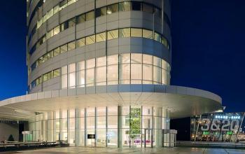 Modern exterior of office building located at De Entree 99-197, Amsterdam South East, illuminated at night.