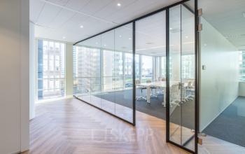 Modern office space rental at De Entree 230, Amsterdam South East with glass partitions and a conference room.