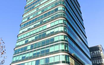 Modern glass office building at De Entree 230, Amsterdam South East, perfect for office space rental with expansive views and contemporary design.