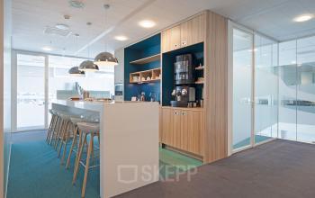 Modern office space rental at Parnassusweg 819, Amsterdam Zuidas, featuring a well-equipped pantry with sleek design and sitting area.