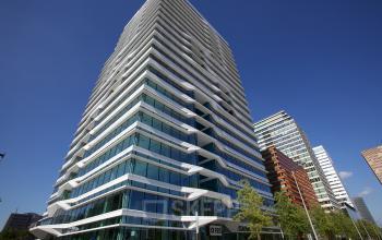 Modern office space rental at Parnassusweg 819 in Amsterdam Zuidas showcasing its striking architecture and reflective glass facade.