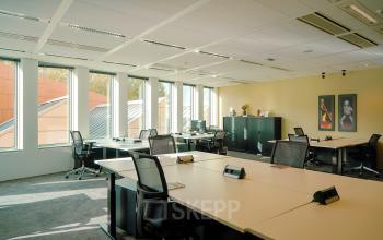 Bright office space at Jachthavenweg 109-A in Amsterdam Zuidas with multiple desks, chairs, and large windows.