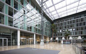 Modern office space rental at Zuidplein 36, Amsterdam Zuidas with glass facade and spacious atrium.