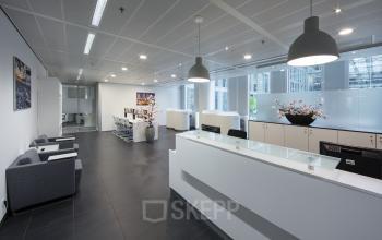 Sleek office space rental at Zuidplein 36, Amsterdam Zuidas, featuring modern furniture and a welcoming reception area.