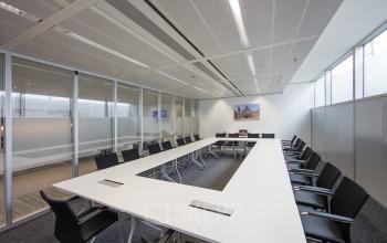 Sleek conference room available for office space rental at Zuidplein 36, Amsterdam Zuidas, equipped with a long table and chairs.