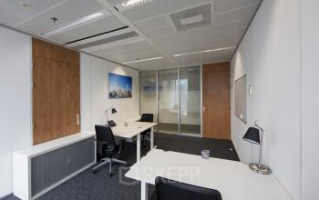 Modern Zuidplein 36 office space rental in Amsterdam Zuidas with desks, chairs, and wooden accents.