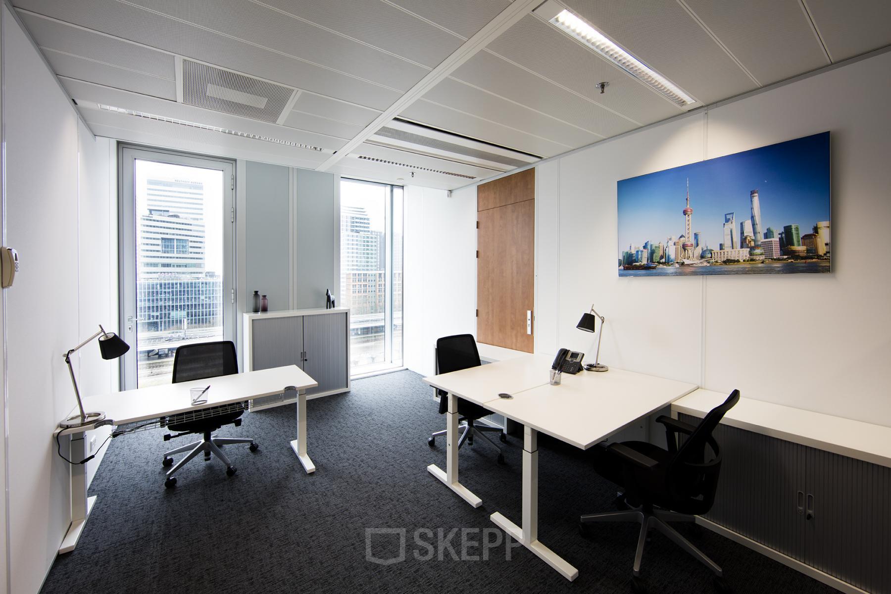 Modern office space rental at Zuidplein 36, Amsterdam Zuidas, with ergonomic chairs and a vibrant cityscape picture on the wall.