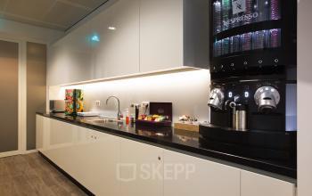 Sleek pantry area in an office space rental at Strawinskylaan 3051, Amsterdam Zuidas, featuring a coffee machine and snacks.
