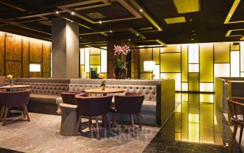 Elegant lounge area at Strawinskylaan 3051 office space rental in Amsterdam Zuidas with comfortable seating and warm lighting.