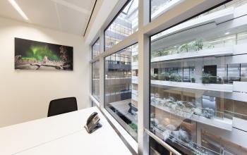 A serene, well-lit office space rental at Strawinskylaan 3051, Amsterdam Zuidas, featuring large windows and modern decor.
