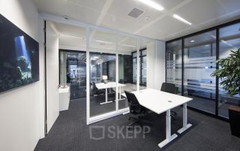 Modern office space rental at Strawinskylaan 3051, Amsterdam Zuidas, with glass partitions and contemporary furnishings.