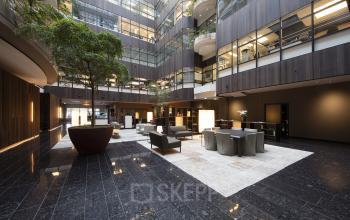 Spacious and modern office space rental at Strawinskylaan 3051, in Amsterdam Zuidas, with stylish seating and lush indoor plants.