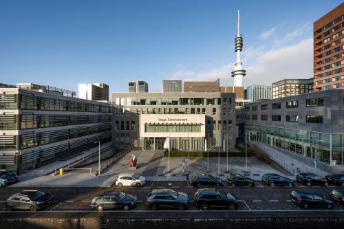Exterior view of an office building at De Boelelaan 30 in Amsterdam Zuidas, with surrounding modern architecture and parked cars. Ideal for those seeking office space rental in a dynamic business district.