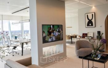 Modern office space with sleek furnishings and large windows offering city views at Strawinskylaan 257, Amsterdam Zuidas. Ideal for office space rental with collaborative workstations and a relaxed atmosphere.