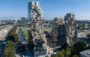 A modern architectural exterior of Beethovenstraat 503 in Amsterdam Zuidas, showcasing unique, contoured facades amidst urban surroundings. Ideal location for office space rental with panoramic views and proximity to key business hubs.