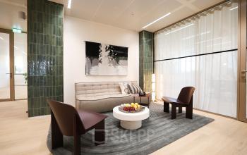 Modern furnished office lounge with a sofa, two chairs, and a coffee table, ideal for office space rental at Beethovenstraat 503, Amsterdam Zuidas.