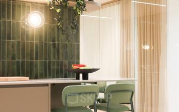 Bright and stylish workspace at Beethovenstraat 503, Amsterdam Zuidas, featuring modern furniture and green accents, perfect for office space rental.