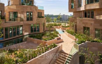 Exterior view of the office complex at Beethovenstraat 503, Amsterdam Zuidas, showcasing modern architecture with tiered gardens and pathways.