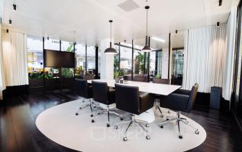 Modern conference room with a large table and sleek black chairs at Fred. Roeskestraat 115, Amsterdam Zuidas. Ideal for office space rental, offering a professional and stylish environment.