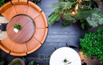A vibrant lounge area at Fred. Roeskestraat 115 in Amsterdam Zuidas, featuring a circular seating arrangement and lush greenery, ideal for office space rental and relaxation.