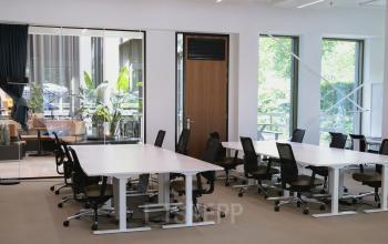 Spacious, modern workspaces with large windows and ergonomic chairs at Fred. Roeskestraat 115, Amsterdam Zuidas, perfect for office space rental with natural light enhancing productivity.